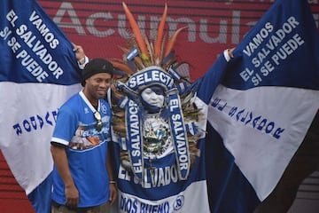 El jugador brasileño Ronaldinho posa con el personaje salvadoreño conocido como el Indio Cuscatleco, en el Estadio Nacional Jorge "Mágico" González en San Salvador, el 8 de agosto de 2017.
Ronaldinho se reunió con unos 500 niños y jóvenes que viven en zonas plagadas por la violencia que afecta a El Salvador y que forman parte del programa de prevención de la Liga de Atletismo Policial impulsado por la Policía Nacional Civil. / AFP PHOTO / Marvin RECINOS