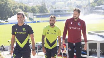 SAN SEBASTIÁN, 23/08/2024.- Los jugadores de la Real Sociedad Brais Méndez (c) y Álex Remiro (d), junto al segundo entrenador, Mikel Labaka, este viernes momentos antes de una sesión de entrenamiento en el campo de entrenamiento de Zubieta, en San Sebastián. EFE/Javier Etxezarreta