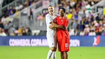 Brazilian former football player Ronaldinho (R) hugs Colombian former football player Mario Yepes during the exhibition "Leyendas Conmebol" football match at DRV PNK Stadium in Fort Lauderdale, Florida, on December 5, 2023. (Photo by Chris Arjoon / AFP)