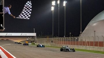 El ex jugador de fútbol británico David Beckham ondea la bandera a cuadros cuando el piloto británico de Mercedes, Lewis Hamilton, cruza la línea de meta durante el Gran Premio de Fórmula Uno de Bahrein en el circuito de Sakhir