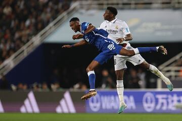 El defensor francés del Real Madrid Aurelien Tchouameni lucha en un salto con el mediocampista saudita de Hilal, Mohamed Kanno, durante el partido de fútbol final de la Copa Mundial de Clubes.