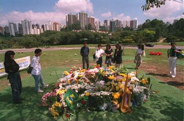 Foto del 3 de mayo de 1994, dos días después del accidente mortal de Senna en Imola, donde aficionados llevaron flores en luto por el piloto brasileño.