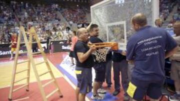 Operarios retiran la canasta rota por un jugador de Macedonia.