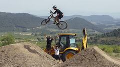 Bienve saltando en uno de los saltos del campillo de Biketrails Valencia con los shapers/builders al fondo levantando los brazos en se&ntilde;al de victoria. 