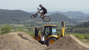 Bienve saltando en uno de los saltos del campillo de Biketrails Valencia con los shapers/builders al fondo levantando los brazos en señal de victoria.