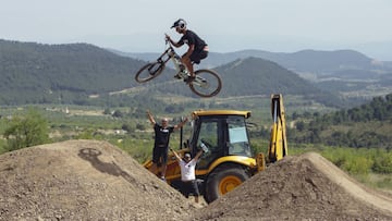 Bienve saltando en uno de los saltos del campillo de Biketrails Valencia con los shapers/builders al fondo levantando los brazos en se&ntilde;al de victoria. 