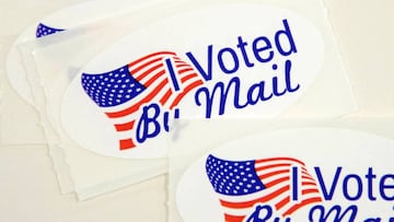 Stickers that read &quot;I Voted By Mail&quot; sit on a table waiting to be stuffed into envelopes by absentee ballot election workers  at the Mecklenburg County Board of Elections office in Charlotte, NC on September 4, 2020. - The US election is officia