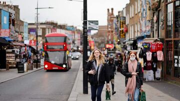 Shoppers, some wearing face coverings to combat the spread of the coronavirus, walk past stores in Camden in London, on January 7, 2022, as UK businesses and consumers face mounting fallout from surging inflation, including higher interest rates. - Restrictions imposed in the wake of the Omicron coronavirus variant have "wiped out" much of a recent recovery enjoyed by UK bricks-and-mortar stores, the British Retail Consortium revealed Friday, January 7. (Photo by Tolga Akmen / AFP)