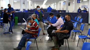 People wait to receive a dose of Pfizer-BioNTech coronavirus disease (COVID-19) vaccine at a vaccination center as the Salvadoran government authorized a fourth dose of the vaccine in San Salvador, El Salvador, March 22, 2022. REUTERS/Jose Cabezas