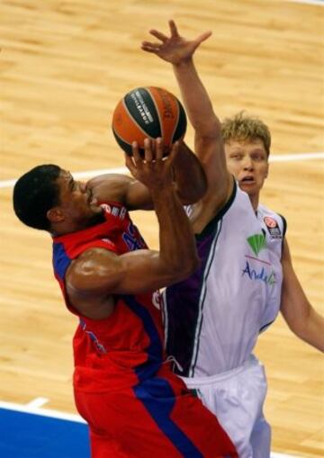 Kuzminskas (Unicaja) intenta evitar la canasta de Hines.