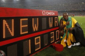 En los Juegos Olímpicos de Pekín 2008 consiguió en los 100m un registro de 9,69. También en los 200m implantó una nueva marca mundial en 19,30 y en la carrera de relevos 4×100 junto a sus compañeros jamaicanos Nesta Carter, Michael Frater y Asafa Powell marcaron el registro mundial y olímpico en 37,10. Tales hazañas le consagraron como el primer atleta en ganar tres pruebas olímpicas desde Carl Lewis en 1984. 
En la imagen Usain Bolt posa junto a la marca mundial registrada en los 200m.