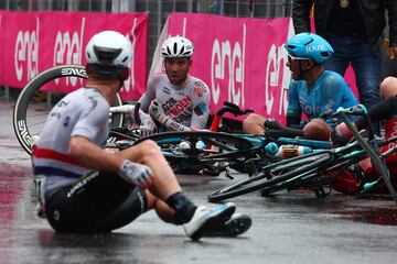 Andrea Vendrame, Mirco Maestri y Mark Cavendish charlan en el suelo tras haberse caído al final de la etapa.