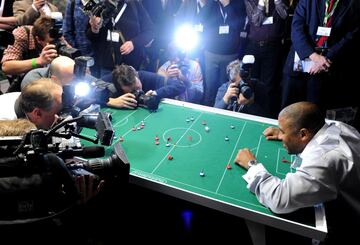 El fútbol de mesa. Se recrea un partido con once figuras de pequeño tamaño que se deslizan sobre un tapete tras el golpeo con un dedo por parte del jugador. 
