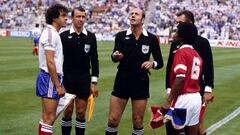 The two captains, France's Michel Platini (l) and Kuwait's Sa'ad Abdul Aziz Al-Houti (r), keep their eyes on the money as referee Miroslav Stupar (c) tosses the coin before the match  (Photo by Peter Robinson - PA Images via Getty Images)
