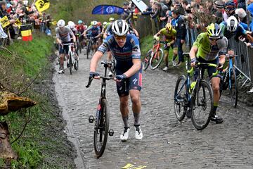 El ciclista belga Tim Merlier y el alemán Georg Zimmermann compiten pasando por el sector adoquinado de Taaienberg. 