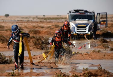 El camión Iveco del piloto neerlandés  Martin Van Den Brink, el copiloto Rijk Mouw y el mecánico Erik Kofman intentan sacar su camión del barro durante la novena etapa.
