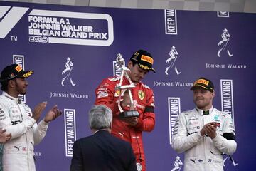 Winner Ferrari's Monegasque driver Charles Leclerc (2R) holds his trophy next to second placed Mercedes' British driver Lewis Hamilton (L) and third placed Mercedes' Finnish driver Valtteri Bottas (R) on the podium after the Belgian Formula One Grand Prix at the Spa-Francorchamps circuit in Spa on September 1, 2019. (Photo by Kenzo TRIBOUILLARD / AFP)