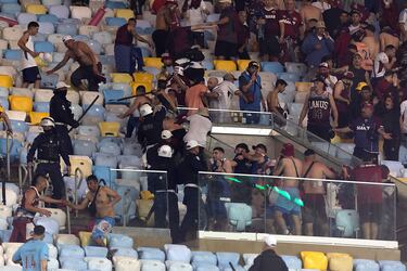 Policías brasileños se enfrentan con hinchas del Club Atlético Lanús durante el partido de vuelta de los cuartos de final de la Copa Sudamericana frente al Fluminense Football Club en el Estadio Maracaná de Río de Janeiro.