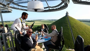 People sit at tables on a structure suspended from a crane at a height of fifty metres, during a Michelin-starred dinner event known as "Dinner in the Sky", near the Lion's Mound (Butte du Lion) on the battlefield of the Battle of Waterloo, in Braine-l'Alleud, Belgium, June 11, 2025. REUTERS/Yves Herman