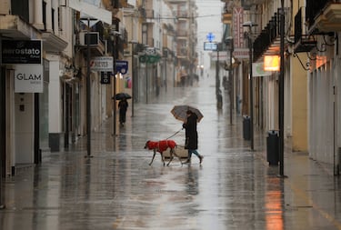La gente camina en una zona comercial de Ronda bajo la lluvia mientras la tormenta 'Leonardo' azota el sur del país.