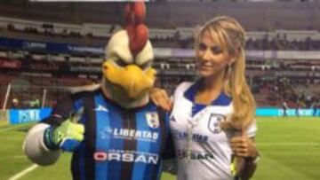 La conductora posa junto a la mascota de Gallos Blancos.