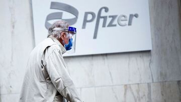 (FILES) In this file photo a man wearing facemask and shield walks past the Pfizer headquarters in New York on March 11, 2021, one year after the pandemic was officially declared. - Pfizer sharply increased its projections for 2021 revenues and profits on May 4, 2021, citing much higher sales from its Covid-19 vaccine sales.The drugmaker now estimates 2021 revenues of $26 billion from the vaccine, up from $15 billion previously and reflecting 1.6 billion doses expected to be delivered this year under contracts signed through mid-April. (Photo by Kena Betancur / AFP)