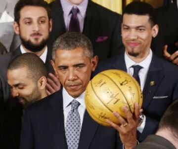 El presidente estadounidense, Barack Obama recibe un balón autografiado de manos del jugador Kawhi Leonard.