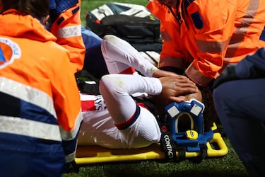 Desire Doue sale del campo entre lágrimas y ayudado para ser trasladado en camilla.