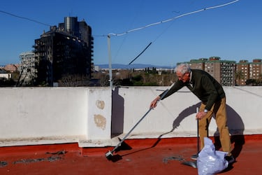 Un vecino de la zona limpia los restos de ceniza tras el incendio.