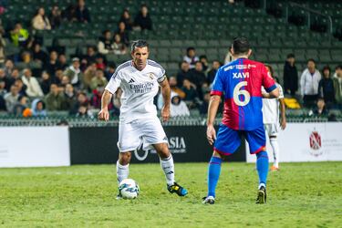 Luis Figo encara a Xavi.