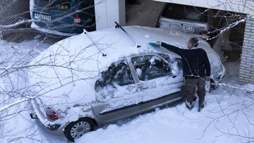 Un hombre retira la nieve que hay sobre su coche tras el paso de la nevada fruto del temporal Filomena por la Comunidad de Madrid (Espa&ntilde;a), a 10 de enero de 2021. La Comunidad de Madrid ha recordado a  los madrile&ntilde;os, a trav&eacute;s de un c