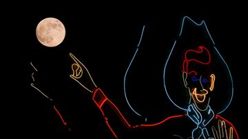 La luna sale junto a un Big Tex de ne¨®n en la Feria Estatal de Texas en Dallas.