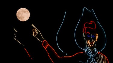 La luna sale junto a un Big Tex de neón en la Feria Estatal de Texas en Dallas.
