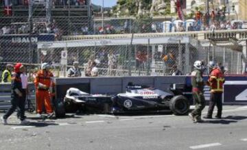 Personal de seguridad retirando los restos del coche tras el accidente de Pastor Maldonado.