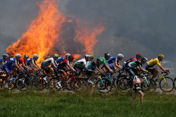 El pelotón, con Greg Van Avermaet con el maillot amarillo pasa cerca de unas pacas de paja de heno.