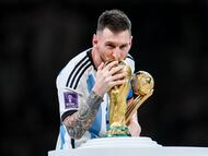 LUSAIL CITY, QATAR - DECEMBER 18: Lionel Messi of Argentina kisses the FIFA World Cup Qatar 2022 Winners' Trophy while holding the adidas Golden Boot award after the FIFA World Cup Qatar 2022 Final match between Argentina and France at Lusail Stadium on December 18, 2022 in Lusail City, Qatar. (Photo by Maja Hitij - FIFA/FIFA via Getty Images)