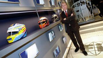 Nigel Mansell posando junto a cascos de pilotos de F1, entre ellos uno de Fernando Alonso.