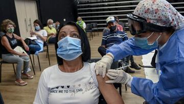 A woman is inoculated with the Oxford/AstraZeneca vaccine against COVID-19 at a vaccination center, amid the novel coronavirus pandemic, in Medellin, Colombia, on April 7, 2021. - Colombian President Ivan Duque on Sunday reinforced the curfews he recently imposed in the cities with the highest hospital occupancy to contain a new wave of covid-19 infections and deaths. (Photo by JOAQUIN SARMIENTO / AFP)