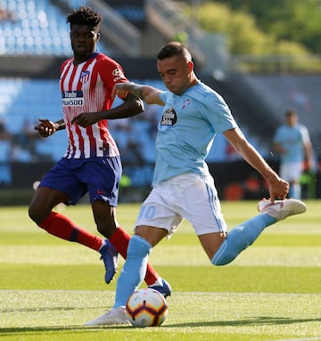 El delantero del Celta de Vigo Iago Aspas centra el balón junto al ghanés Thomas Partey, del Atlético de Madrid