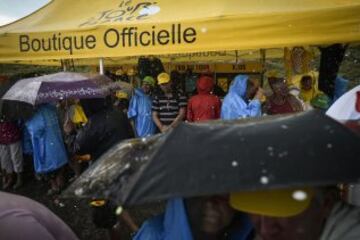 Espectadores se protegen de la lluvia.