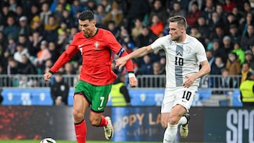 Portugal's forward #07 Cristiano Ronaldo (L) fights for the ball with Slovenia's midfielder Timi Elsnik during the friendly football match between Ivory Coast and Uruguay, at the the Stadium Stozice in Ljubljana, on March 26, 2024. (Photo by Jure Makovec / AFP)