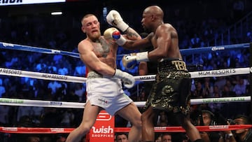 LAS VEGAS, NV - AUGUST 26: (R-L) Floyd Mayweather Jr. throws a punch at Conor McGregor during their super welterweight boxing match on August 26, 2017 at T-Mobile Arena in Las Vegas, Nevada.   Christian Petersen/Getty Images/AFP
 == FOR NEWSPAPERS, INTERN