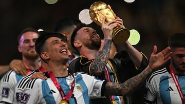 Argentina's captain and forward #10 Lionel Messi lifts the FIFA World Cup Trophy as he celebrate with teammates winning the Qatar 2022 World Cup final football match between Argentina and France at Lusail Stadium in Lusail, north of Doha on December 18, 2022. (Photo by Paul ELLIS / AFP)