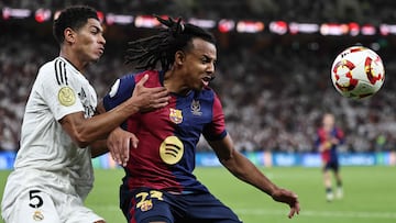 Real Madrid's English midfielder #5 Jude Bellingham fights for the ball with Barcelona's French defender #23 Jules Kounde during the Spanish Super Cup final football match between Real Madrid and Barcelona at the King Abdullah Sport City in Jeddah on January 12, 2025. (Photo by FADEL SENNA / AFP)