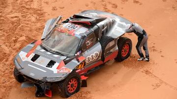 Audi's hybrid Spanish driver Carlos Sainz reacts by his car after a crash during Stage 9 of the Dakar 2023 rally between Riyadh and Haradh in Saudi Arabia on January 10, 2023. (Photo by FRANCK FIFE / AFP) (Photo by FRANCK FIFE/AFP via Getty Images)