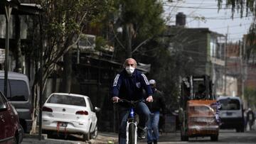 Argentine priest Lorenzo De Vedia, known as &quot;Padre Toto&quot; (Father Toto), rides his bike returning to the Caacupe Virgin parish church at the Villa 21 shantytown amid the lockdown against the spread of the novel coronavirus, COVID-19, in Buenos Aires, Argentina, on July 31, 2020. - The so-called x93shantytown priestsx94, who lead parish churches in shantytowns of the Argentinian capital, not only conduct masses, but also organize, accompany, give solutions. Their roles grew amid the pandemic, which deepened shortages and made them more visible. (Photo by JUAN MABROMATA / AFP)