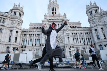 Una corredora vestida de tiburón pasa por delante del Ayuntamiento de Madrid.