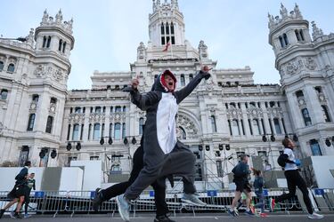 Una corredora vestida de tiburón pasa por delante del Ayuntamiento de Madrid.