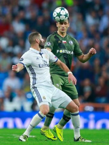 MADRID, SPAIN - OCTOBER 18: Karim Benzema of Real Madrid and Tomasz Jodlowiec of Legia Warszawa compete for the ball during the UEFA Champions League Group F match between Real Madrid CF and Legia Warszawa at Bernabeu on October 18, 2016 in Madrid, Spain.