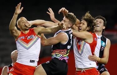 Sam Reid y Tom Hickey, de los Sydney Swans, y Darragh Joyce y Rowan Marshall, de los St Kilda Saints, compiten por hacerse con un balón durante su partido de la Liga australiana de fútbol, aunque la fotografía pudiera
hacer pensar que se trata de un deporte de lucha, a tenor del ímpetu de los jugadores.
